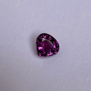 May include: A heart-shaped purple gemstone with a faceted cut.