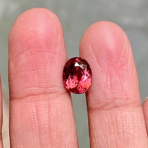 K&ouml;nnte beinhalten: Ein lebhafter, ovaler Edelstein in Pink mit Facetten.