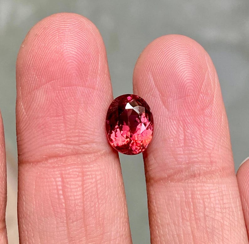 K&ouml;nnte beinhalten: Ein lebhafter, ovaler Edelstein in Pink mit Facetten.