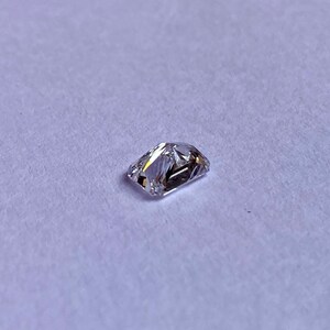 以下が含まれることがあります： わずかに黄色がかった透明な長方形のファセットカットの宝石
