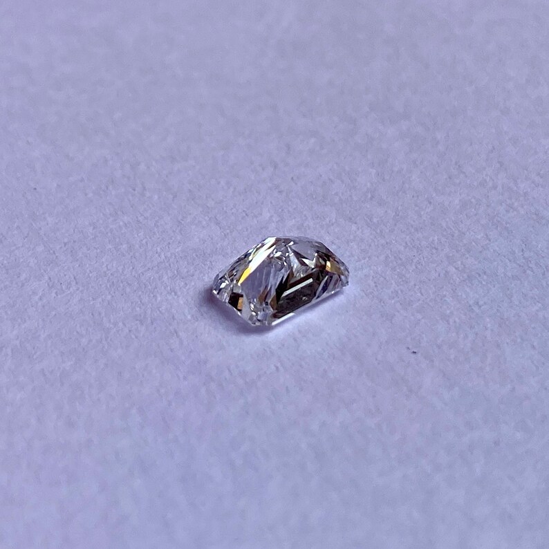 以下が含まれることがあります： わずかに黄色がかった透明な長方形のファセットカットの宝石