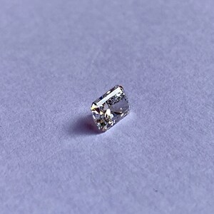以下が含まれることがあります： わずかに黄色がかった透明な長方形のファセットカットの宝石