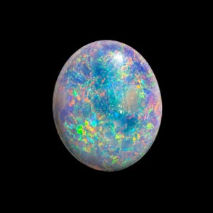 May include: An oval-shaped cabochon gemstone featuring a translucent white base with a vibrant play-of-color. The stone displays intense flashes of neon blue, green, yellow, and orange light across its polished, rounded surface against a black background.