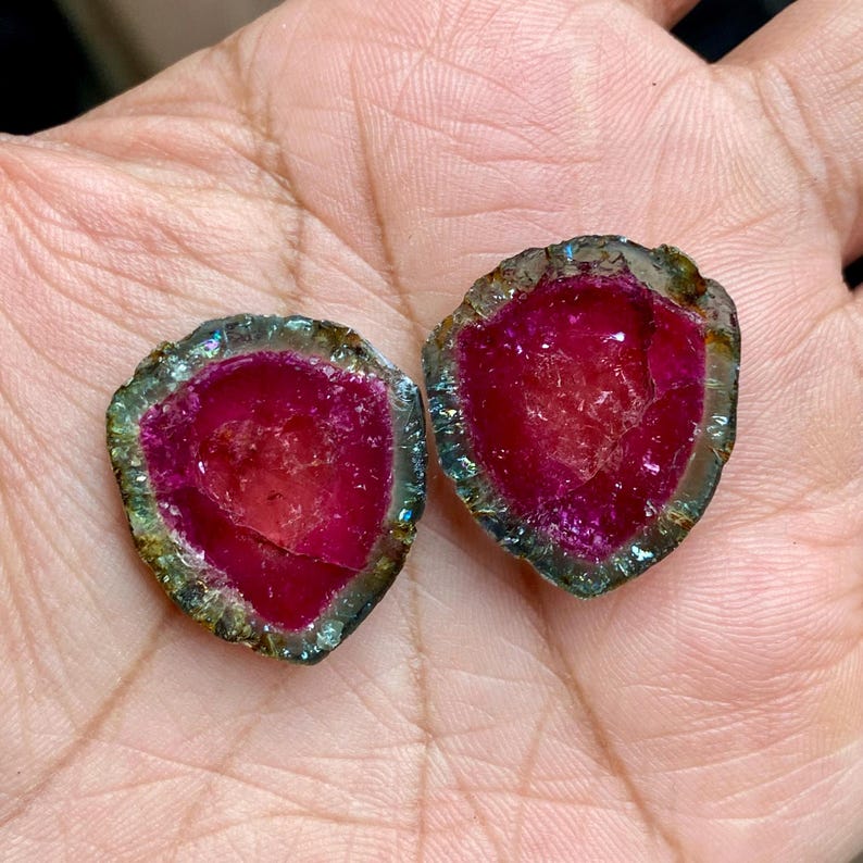 Pu&ograve; includere: Due cabochon di turmalina watermelon rosa e verde con finitura naturale, grezza e lucidata. I cabochon sono tagliati a met&agrave; per rivelare il cristallo all'interno.