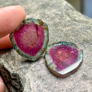 Pu&ograve; includere: Due fette di tormalina rosa, verde e argento con un aspetto stratificato, simile a un cristallo.