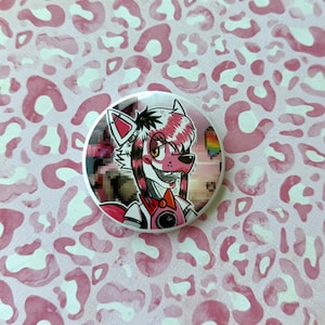 May include: A round button featuring a cartoon character with pink and white fur, a red bow tie, and a pixelated background. The button has a white border and is set against a pink leopard print background.
