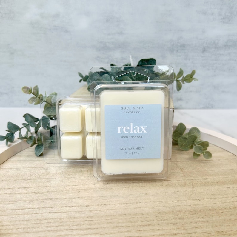 Puede incluir: Un recipiente de pl&aacute;stico transparente con una fusi&oacute;n de cera de soja blanca en su interior. La fusi&oacute;n de cera est&aacute; etiquetada como "relax linen + sea salt" y es un producto de Soul & Sea Candle Co.