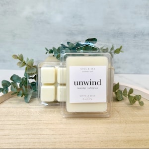 Puede incluir: Un derretido de cera de soja blanco en un recipiente de pl&aacute;stico transparente con el texto "SOUL & SEA CANDLE CO unwind lavender + white tea SOY WAX MELT 2 oz | 57 g"