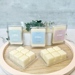 Puede incluir: Tres fundentes de cera en envases de pl&aacute;stico transparente. Los fundentes de cera est&aacute;n etiquetados como "calm", "relax" y "reset". Los fundentes de cera est&aacute;n en una bandeja de madera con un fondo marr&oacute;n claro.