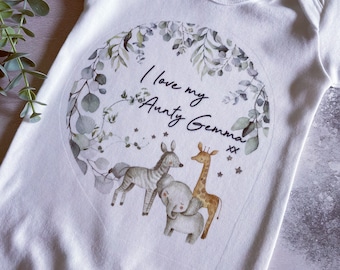 May include: White baby onesie with a green leafy wreath and a giraffe, zebra, and elephant illustration. The text "I love my Aunty Gemma xx" is inside the wreath.