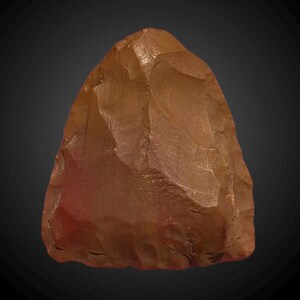 May include: A reddish-brown hand axe made of stone. The axe has a pointed tip and a rounded base. It has been chipped and shaped by hand.