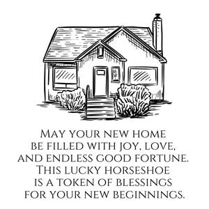 May include: A black and white line drawing of a house with a horseshoe in front of it. The text reads: "May your new home be filled with joy, love, and endless good fortune. This lucky horseshoe is a token of blessings for your new beginnings."