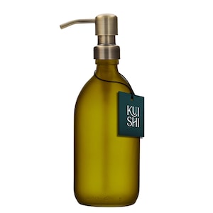 May include: A gold pump bottle with a frosted green glass body. The bottle is labelled with the word "KUI SHI" in white text on a dark green background.
