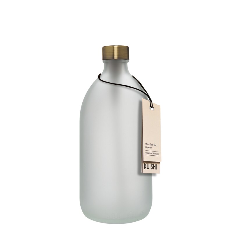 May include: A frosted glass soap dispenser with a gold lid and a brown paper tag that reads "Amber Glass Soap Dispenser" and "KUISHI".