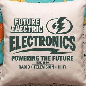 May include: A square off-white throw pillow featuring dark green text that reads Future Electric Electronics, Powering The Future, Est. 1956, Radio, Television, Hi-Fi, accompanied by a large lightning bolt graphic enclosed in an oval shape.