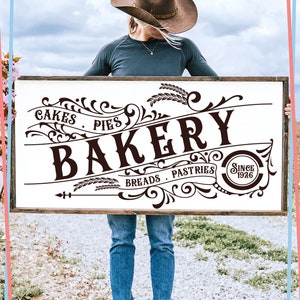 May include: A vintage-style sign for a bakery, featuring the word "Bakery" in a large, ornate font. The sign also includes the words "Cakes, Pies, Breads, Pastries" and "Since 1926".