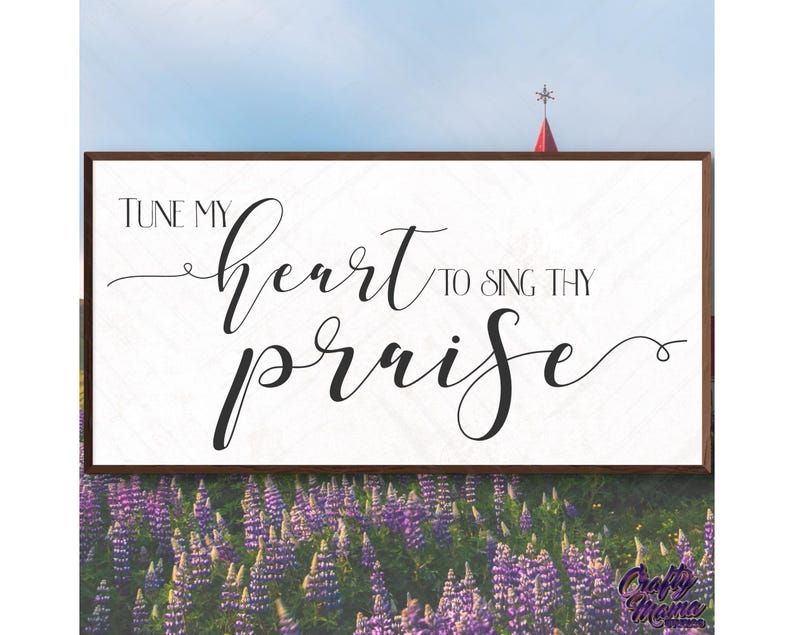 May include: A white wooden sign with brown trim, featuring the text "Tune my heart to sing thy praise" in black cursive font. The sign is displayed against a backdrop of purple lupine flowers.