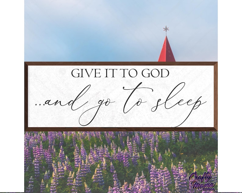 May include: A wooden sign with the text "Give it to God...and go to sleep" in black script font. The sign is brown with a white background and is sitting on a bed of purple lupine flowers.