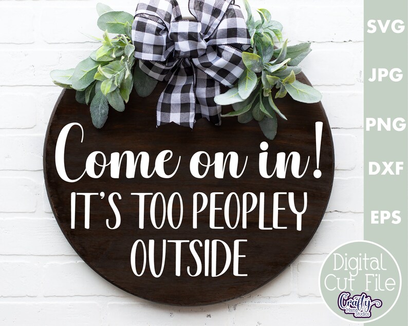 K&ouml;nnte beinhalten: Ein rundes Holzschild mit einer schwarz-wei&szlig;en karierten Schleife und Gr&uuml;n. Das Schild sagt "Come on in! It's too peopley outside."