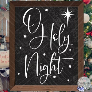 May include: A black chalkboard with a white wooden frame, featuring the text "O Holy Night" in a decorative script font. The text is surrounded by small white stars. A large white star with a six-pointed design is in the upper right corner.