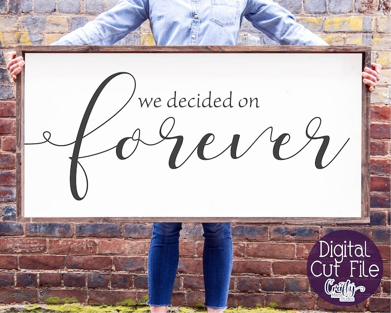 May include: A white wooden sign with the text "we decided on forever" in black cursive font. The sign is being held by a person.
