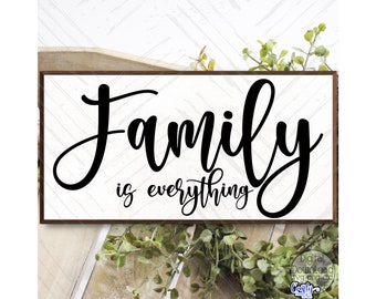 May include: A white wooden sign with a brown frame, featuring black calligraphy that reads "Family is everything".