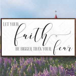 May include: A white wooden sign with black text that reads "Let your faith be bigger than your fear". The sign is in front of a field of purple flowers.