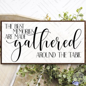 May include: A white wooden sign with black text that reads "The best memories are made gathered around the table".