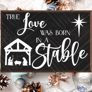 May include: Black chalkboard sign with white text that reads "True Love Was Born In A Stable". A white star is in the top right corner. A white silhouette of a manger scene is in the bottom left corner.
