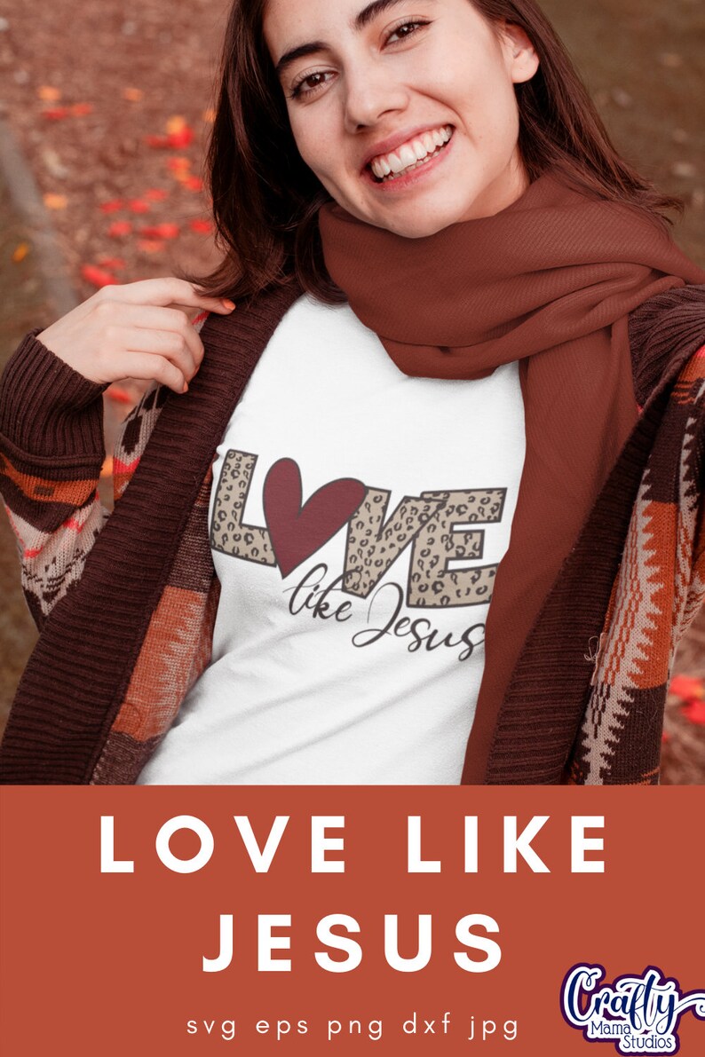 Puede incluir: Una camiseta blanca con un dise&ntilde;o gr&aacute;fico de la palabra "LOVE" en estampado de leopardo con un coraz&oacute;n rojo en el medio y las palabras "like Jesus" escritas debajo. La camiseta la lleva puesta una persona con una bufanda marr&oacute;n.
