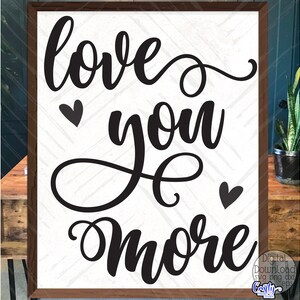 May include: Black and white sign with the text "love you more" in a cursive font. There are two small hearts on either side of the text.