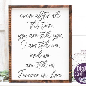 May include: A white sign with a brown wooden frame, featuring a handwritten message that reads "even after all this time, you are still you, I am still me, and we are still us forever in love".