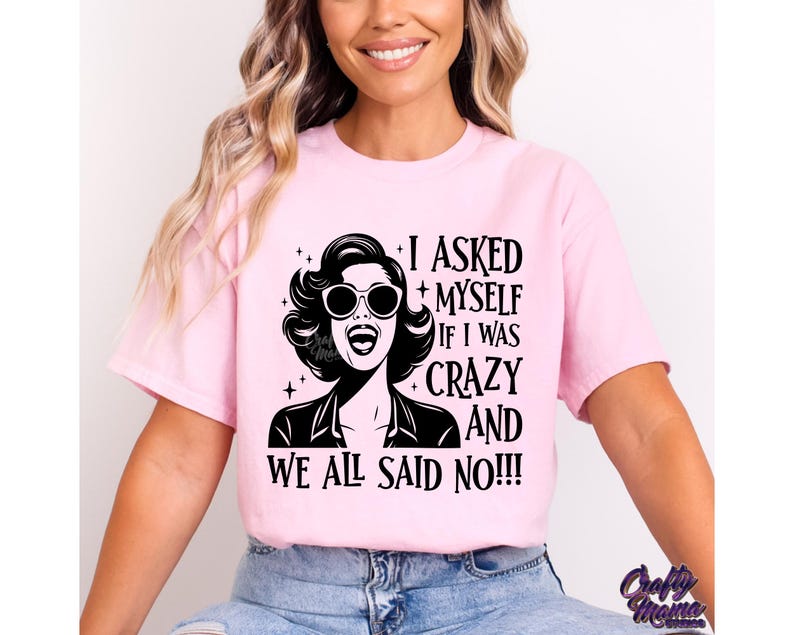 May include: Pink t-shirt with a black and white graphic of a woman wearing sunglasses and the text "I asked myself if I was crazy and we all said no!!"