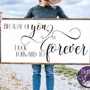 May include: A white wooden sign with black calligraphy that reads "Because of you, I look forward to forever".
