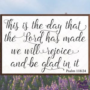 May include: A white sign with black calligraphy text that reads "This is the day that the Lord has made we will rejoice and be glad in it Psalm 118:24".