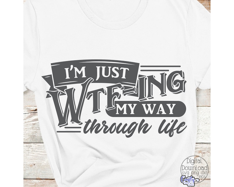 May include: White t-shirt with a dark gray graphic that reads "I'M JUST WTFING MY WAY THROUGH LIFE." The text is in a bold, stylized font. The shirt is made of a soft material.