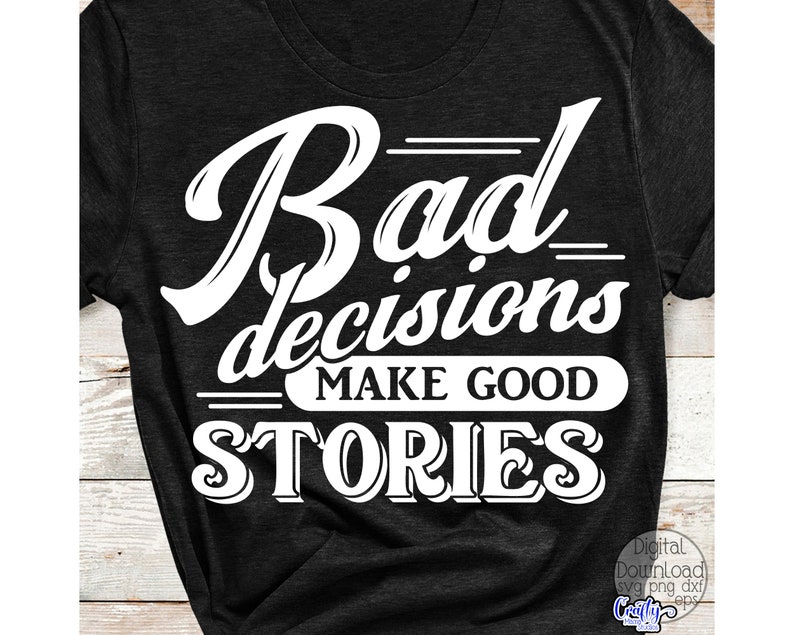 May include: Dark gray t-shirt with the white text "Bad decisions make good stories." The text is in a bold, stylized font. The shirt has short sleeves and a crew neck.