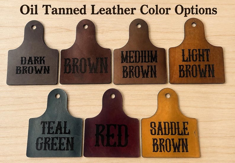 May include: Seven oil tanned leather swatches arranged in two rows, each with a hole at the top. The text Oil Tanned Leather Color Options appears at the top. Labels include Dark Brown, Brown, Medium Brown, Light Brown, Teal Green, Red, and Saddle Brown.