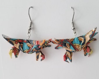 May include: A pair of origami crab earrings with a colorful geometric pattern. The earrings are made of paper and have silver hooks.
