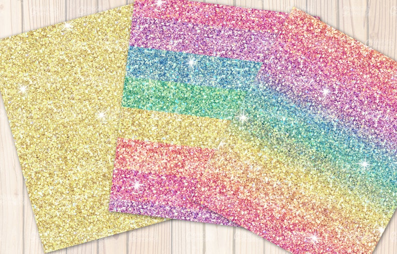 May include: Glitter paper sheets in gold and rainbow colours. The gold sheet is on the left, while the rainbow sheet displays a gradient of colours. The glitter reflects light, creating a sparkling effect. The background is a light wood texture.