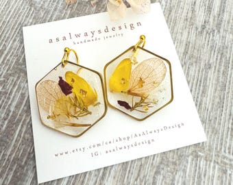 Pendientes colgantes de resina con flores naturales, joyería botánica inspirada en la naturaleza, detalles en latón.