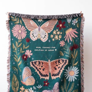 Woven blanket with butterfly and floral pattern and personalized text