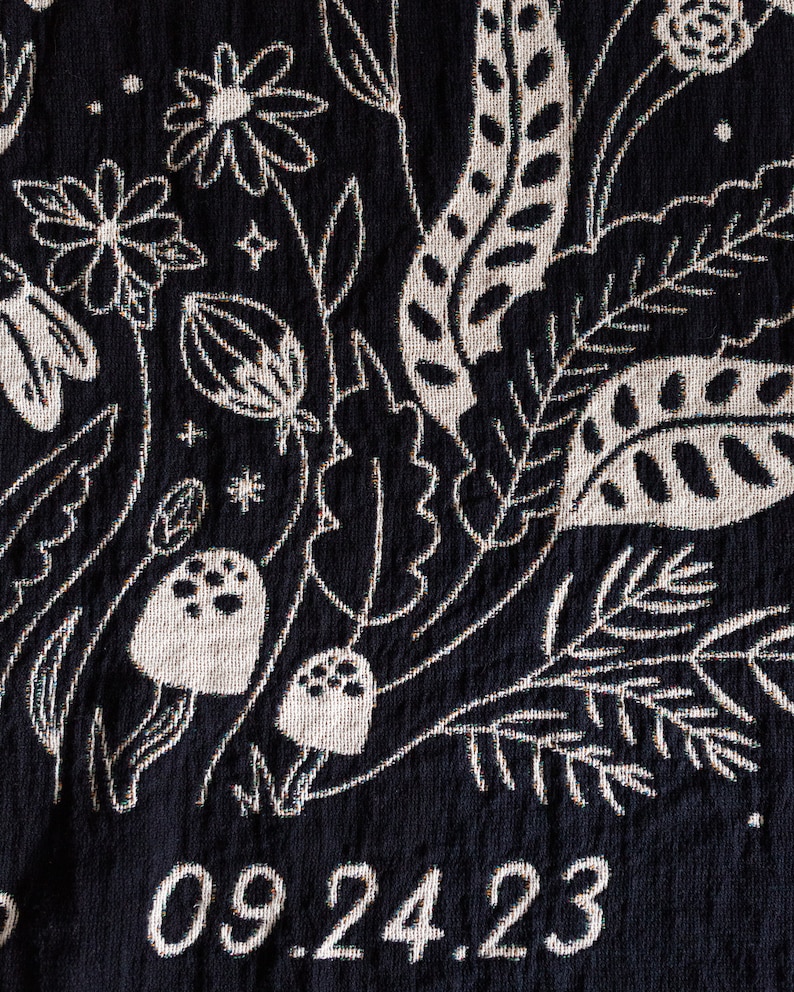 May include: Black fabric with a white floral design and the date 09.24.23 embroidered in white.