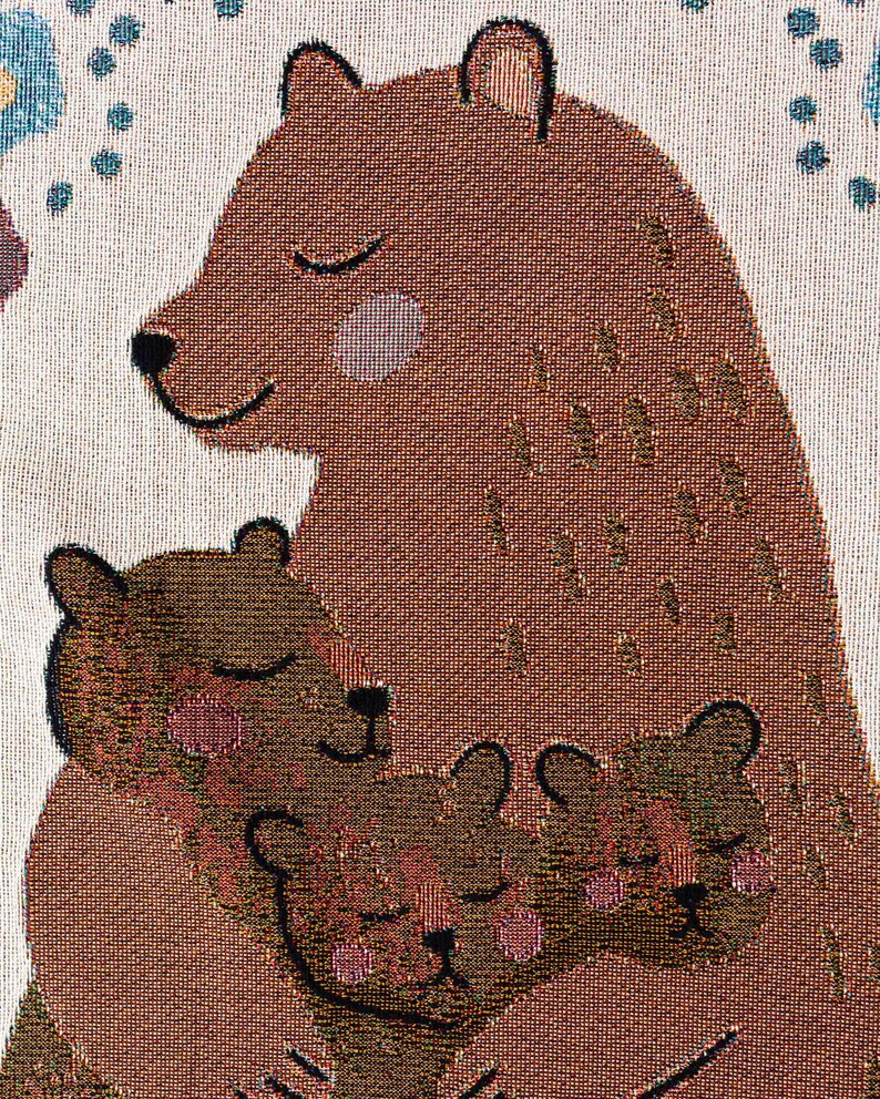 May include: A brown bear with closed eyes is hugging two smaller brown bears with closed eyes. The bears are all smiling and have pink cheeks. The background is a light beige with a blue and white pattern.