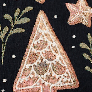K&ouml;nnte beinhalten: Nahaufnahme eines braunen und wei&szlig;en Weihnachtsbaum-Designs auf einem schwarzen Stoffhintergrund. Der Baum ist mit einem goldenen und wei&szlig;en Muster verziert.