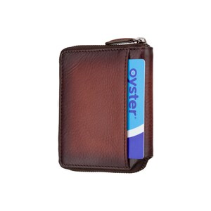 May include: A brown leather zippered wallet with an "oyster" card inserted in the back pocket.