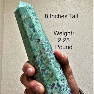 May include: A green and red gemstone obelisk, approximately 8 inches tall and weighing 2.25 pounds. The stone has a polished surface with a mix of green and red hues. The obelisk is held in a hand.