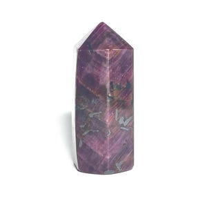 May include: A polished, rectangular crystal with a pointed top. The stone is primarily a deep purple color with streaks of lighter purple, gray, and white. The crystal is standing upright against a white background.