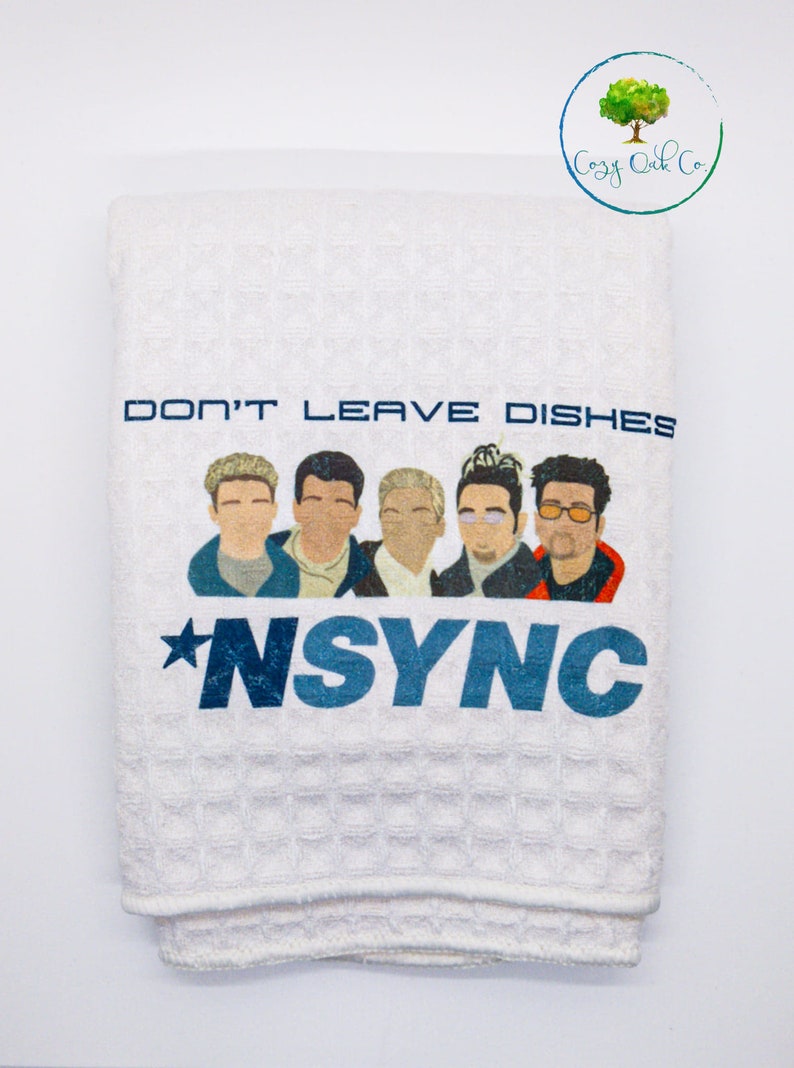 May include: White kitchen towel with a blue and white graphic of the boy band *NSYNC. The text "Don't Leave Dishes" is above the band members.