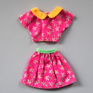 May include: A pink and white floral print doll outfit with a yellow collar and green waistband.